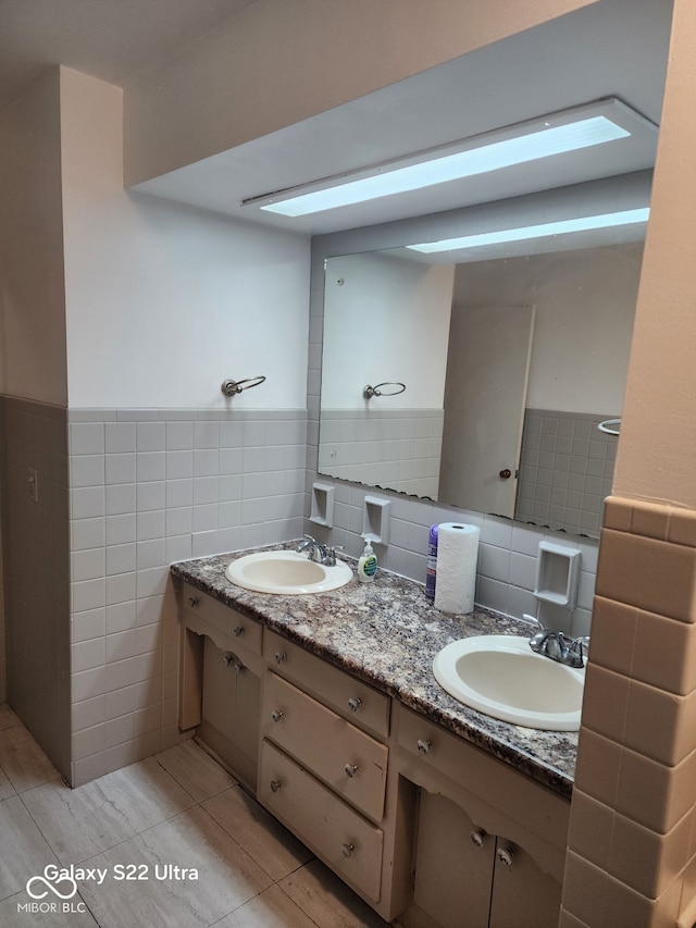 bathroom featuring tile patterned floors, vanity, and tile walls