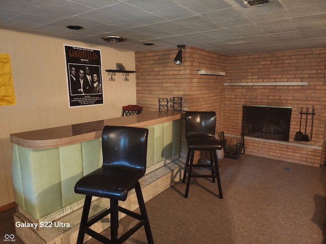 bar with carpet flooring and a brick fireplace