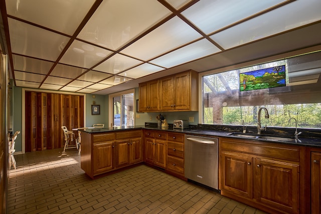 kitchen featuring sink, kitchen peninsula, and stainless steel dishwasher