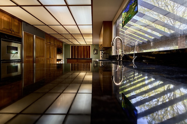 hall featuring tile flooring and plenty of natural light