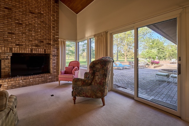 living room with high vaulted ceiling, carpet flooring, and a fireplace