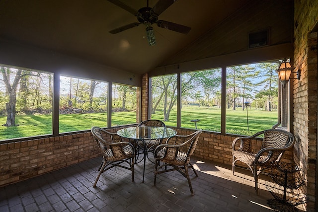 sunroom with ceiling fan and vaulted ceiling