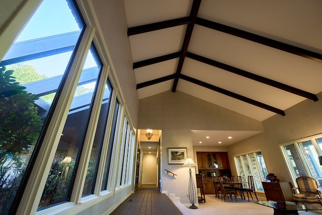 interior space with beamed ceiling and a high ceiling