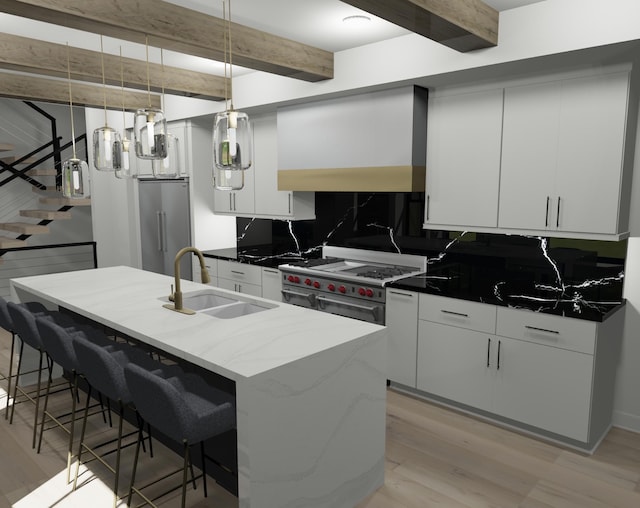 kitchen with premium appliances, a center island with sink, pendant lighting, sink, and tasteful backsplash