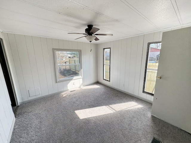 carpeted spare room with ceiling fan and a textured ceiling