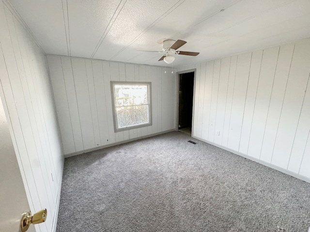 unfurnished bedroom featuring a textured ceiling, light colored carpet, and ceiling fan