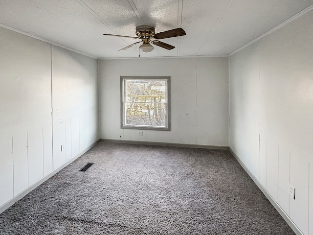 spare room with carpet flooring, a textured ceiling, crown molding, and ceiling fan