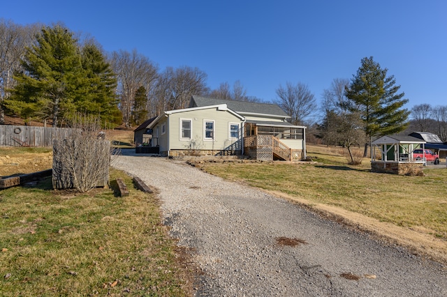 view of front of property featuring a front lawn and a gazebo