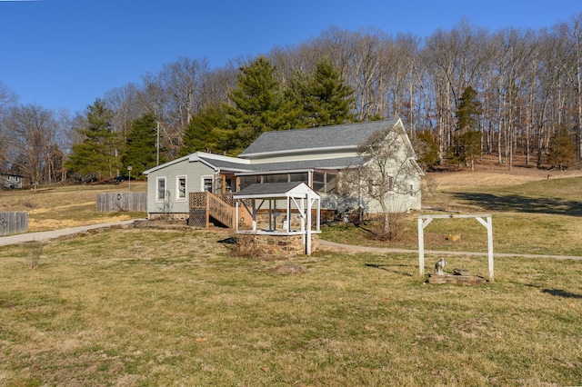 exterior space featuring a gazebo, a wooden deck, and a lawn