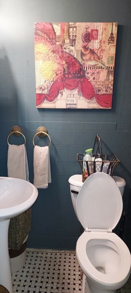 bathroom with tile flooring, toilet, and tile walls