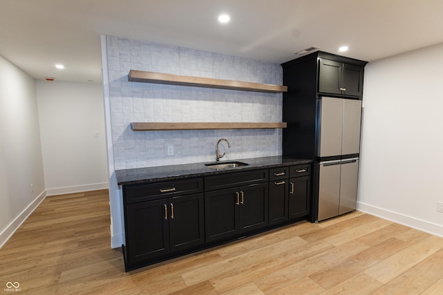 2133 N Talbott St, Indianapolis, IN 46202 - kitchen with open shelves, freestanding refrigerator, decorative backsplash, dark stone countertops, and light wood finished floors