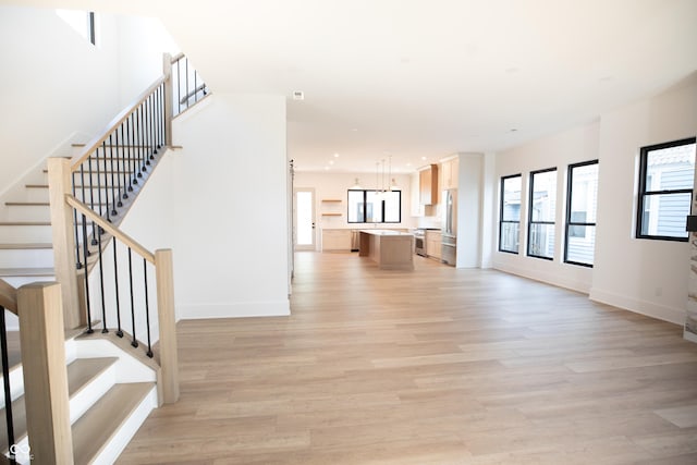 2133 N Talbott St, Indianapolis, IN 46202 - unfurnished living room with light wood finished floors and stairway