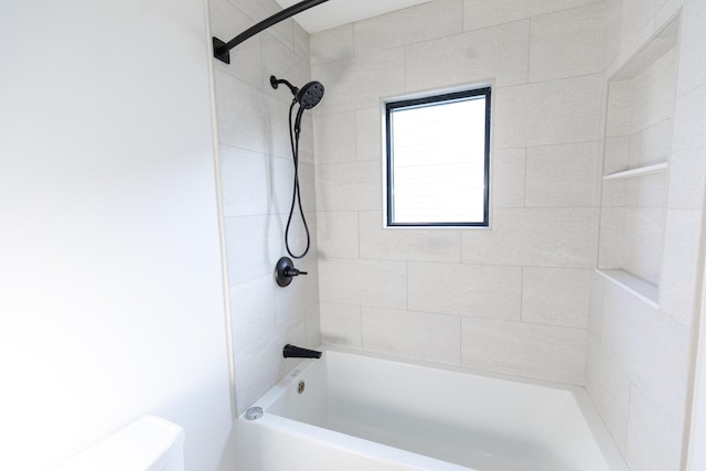 bathroom featuring toilet and tiled shower / bath combo