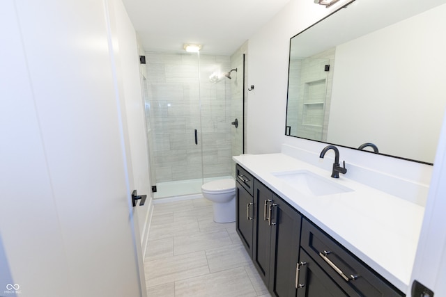 bathroom featuring an enclosed shower, vanity, and toilet