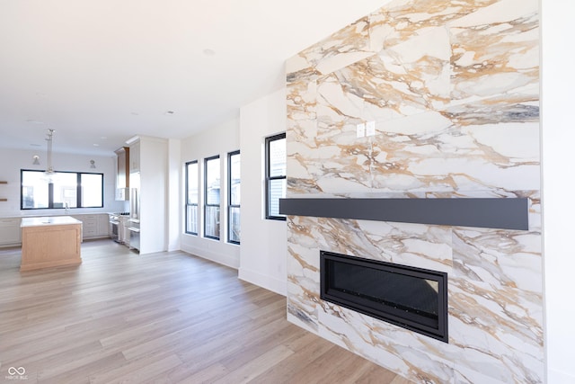 unfurnished living room featuring a large fireplace and light wood-type flooring