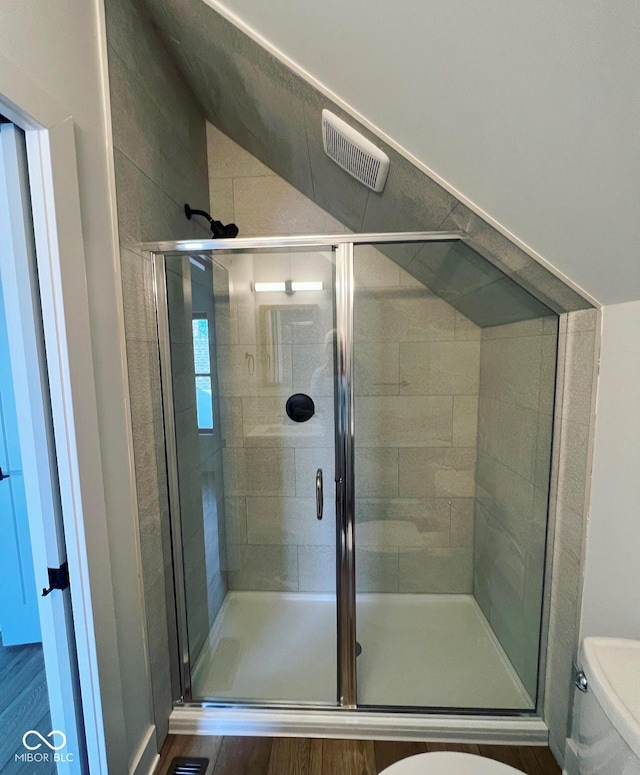 bathroom featuring toilet, hardwood / wood-style floors, and walk in shower