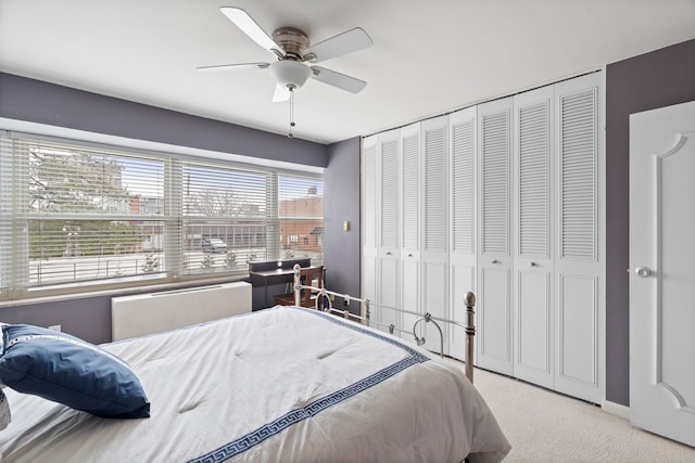 bedroom with a closet, ceiling fan, and light colored carpet