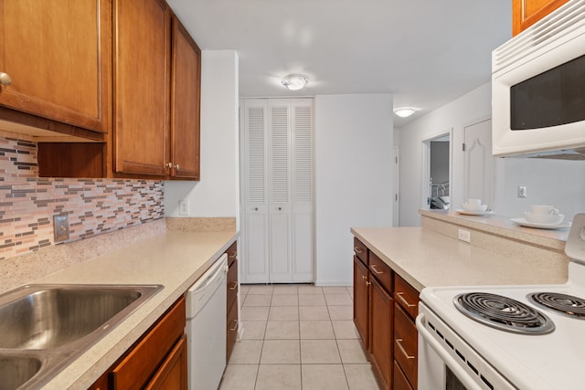 kitchen with tasteful backsplash, white appliances, and light tile flooring