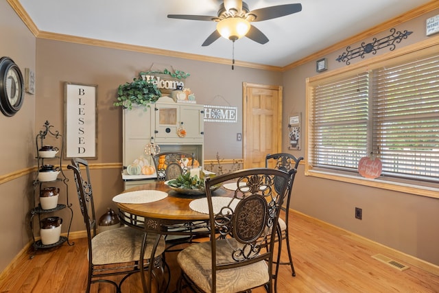 dining area with ceiling fan, ornamental molding, and light hardwood / wood-style floors