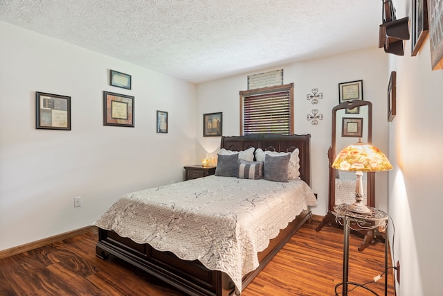 bedroom featuring dark wood-type flooring and a textured ceiling