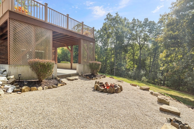 view of yard with a fire pit, a deck, and a patio area