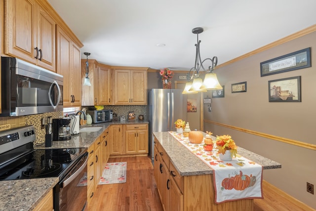 kitchen featuring appliances with stainless steel finishes, tasteful backsplash, light stone counters, and light wood-type flooring