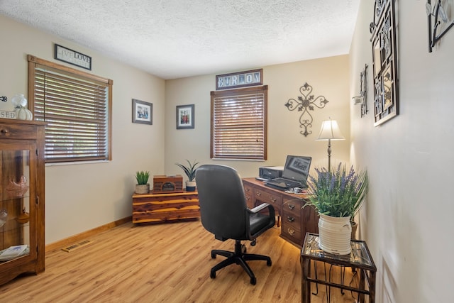 office space featuring a textured ceiling and light hardwood / wood-style floors