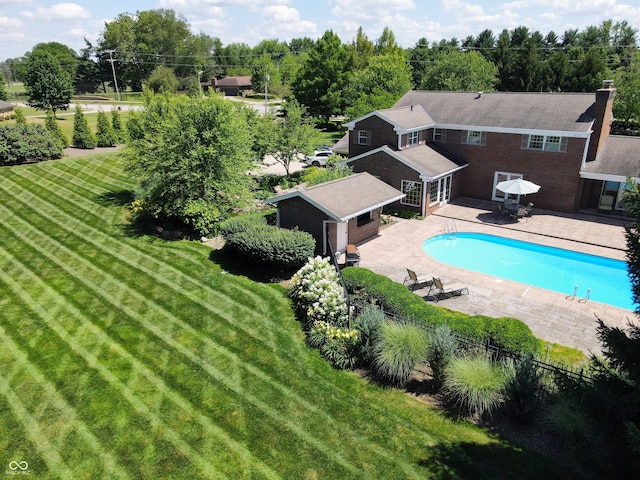 view of pool with a yard, an outbuilding, and a patio area