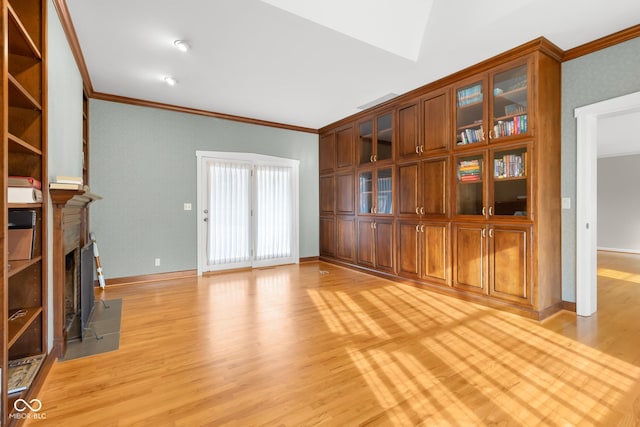 unfurnished living room featuring ornamental molding and light wood-type flooring