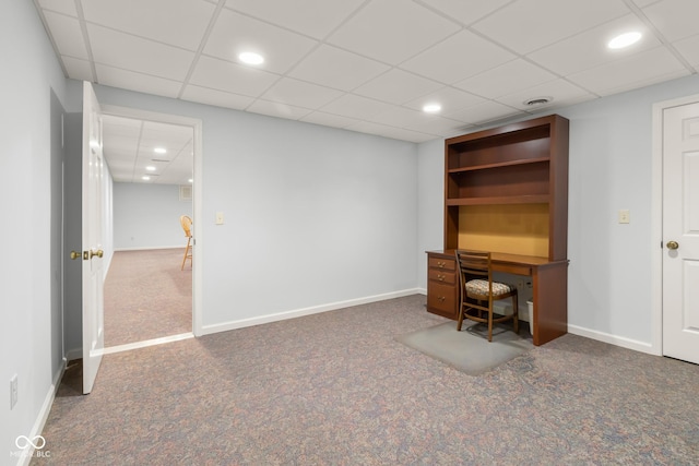 unfurnished office with a drop ceiling and dark colored carpet