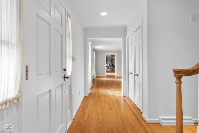 hall with ornamental molding and light hardwood / wood-style floors