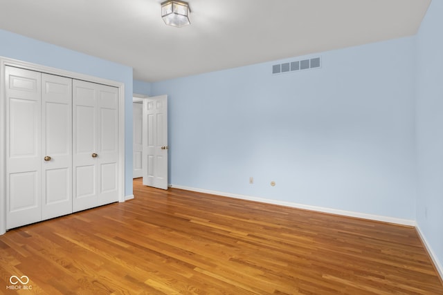 unfurnished bedroom with hardwood / wood-style floors and a closet