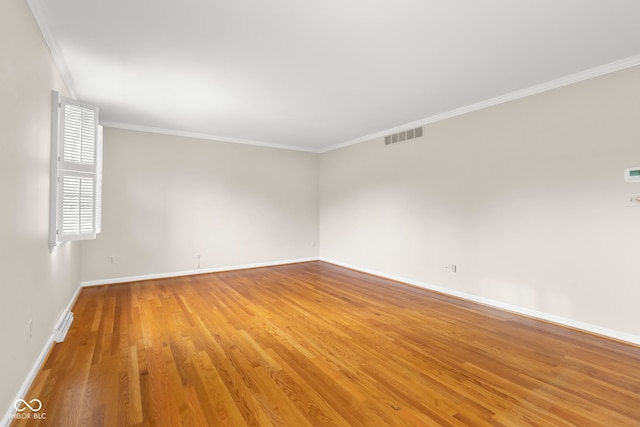 empty room with hardwood / wood-style flooring and ornamental molding