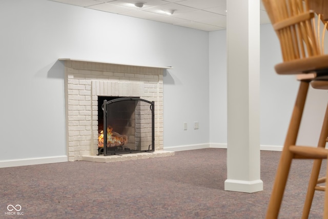 interior space featuring a fireplace, carpet flooring, and a drop ceiling