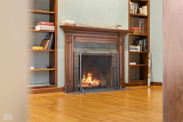 details featuring built in features, wood-type flooring, and a brick fireplace