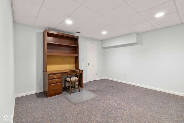 unfurnished office with a paneled ceiling and dark carpet