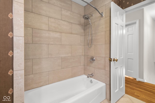 bathroom with hardwood / wood-style flooring and tiled shower / bath combo