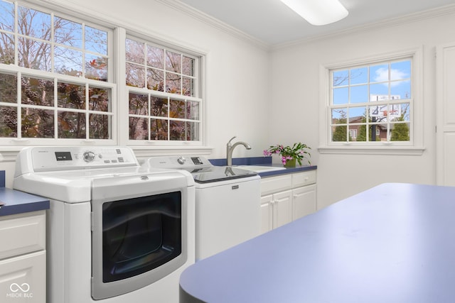 laundry room featuring sink, ornamental molding, washing machine and dryer, and cabinets