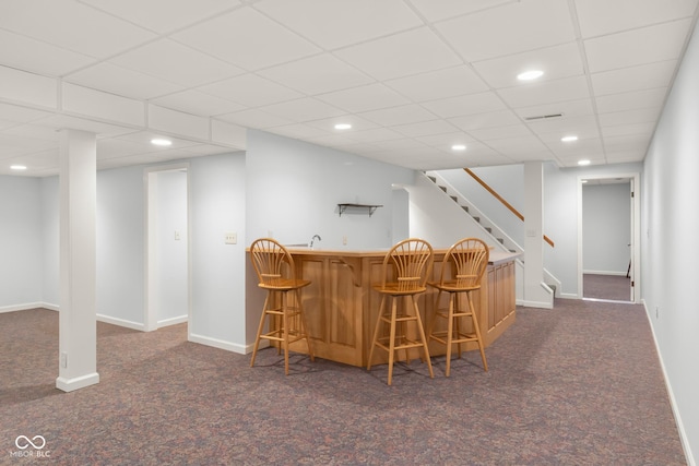 bar featuring dark colored carpet and a drop ceiling