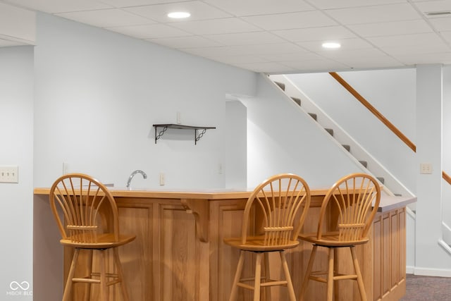 bar with a paneled ceiling and sink