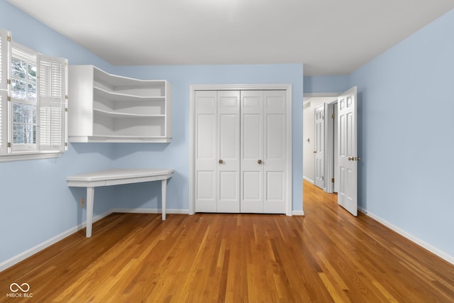 unfurnished bedroom with a closet and light hardwood / wood-style flooring