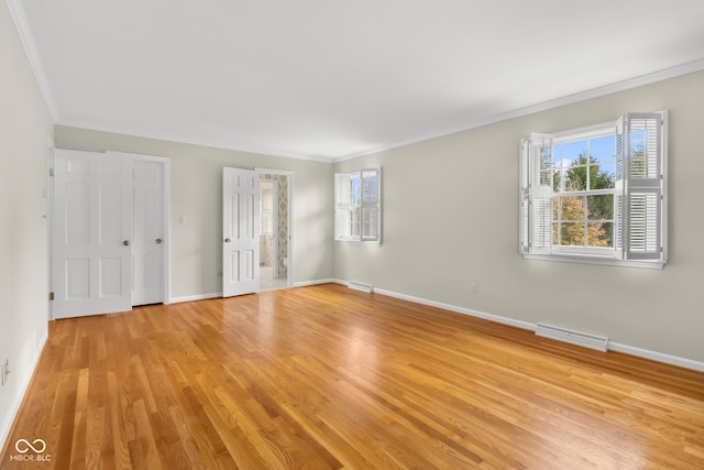 unfurnished room featuring crown molding, a healthy amount of sunlight, and light wood-type flooring