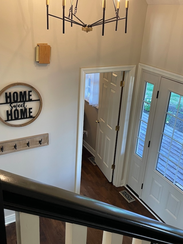 foyer entrance with dark hardwood / wood-style flooring and a notable chandelier