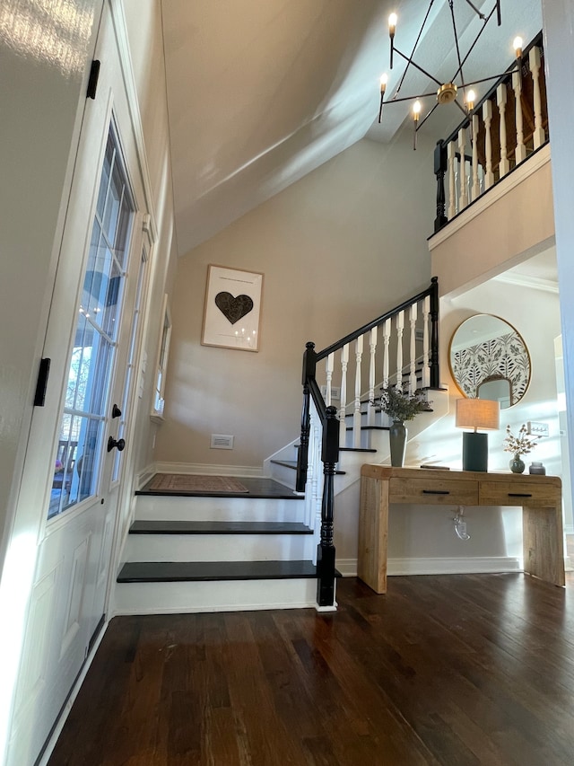 staircase with high vaulted ceiling, hardwood / wood-style floors, a notable chandelier, and french doors