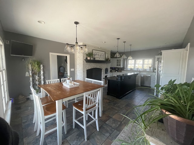 tiled dining area with an inviting chandelier and a large fireplace