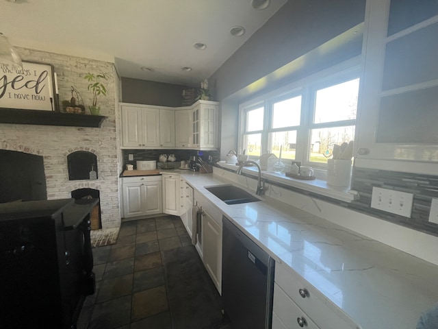 kitchen with white cabinets, sink, dark tile flooring, backsplash, and dishwashing machine