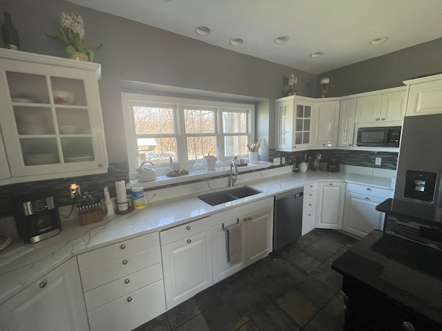 kitchen with tasteful backsplash, black microwave, dishwasher, and sink