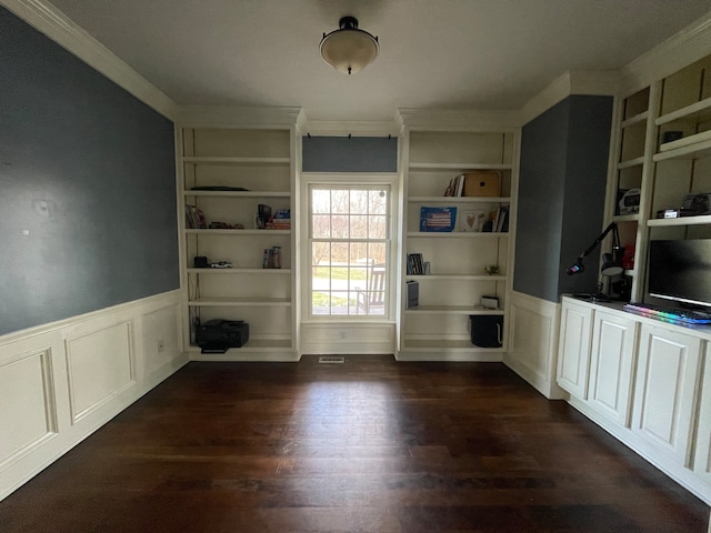 empty room with ornamental molding, built in features, and dark hardwood / wood-style floors