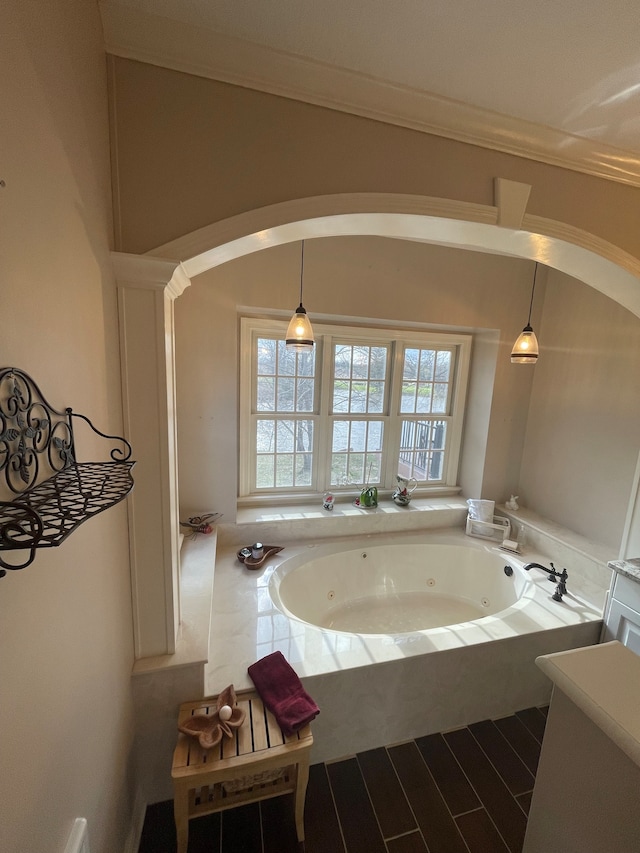 bathroom with crown molding and a tub