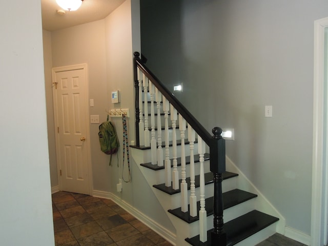 staircase featuring dark tile flooring